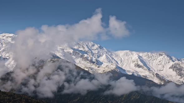 Clouds rising above snowy valley