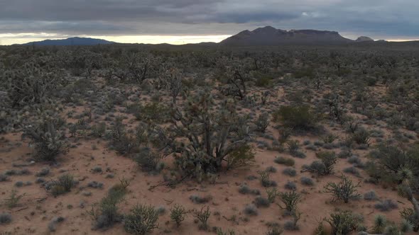 Slow aerial hover backwards over a dramatic desert landscape and impending storm