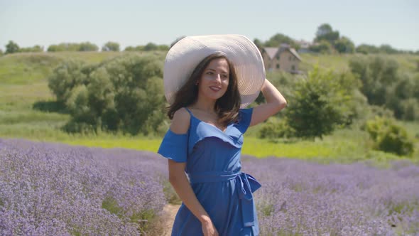 Stylish Lovely Woman Walking in Lavender Blossoms