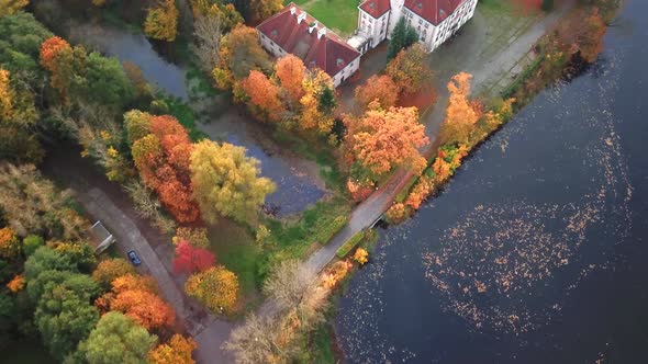 Following the path to Castle in autumn Forest. Located in landscape park with green trees forests in