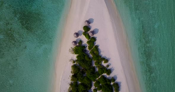 Wide drone tourism shot of a sunshine white sandy paradise beach and aqua turquoise water background