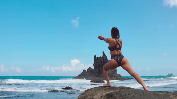 Calm Girl Is Meditating in the Mountains, Bright Sunshine on the Background