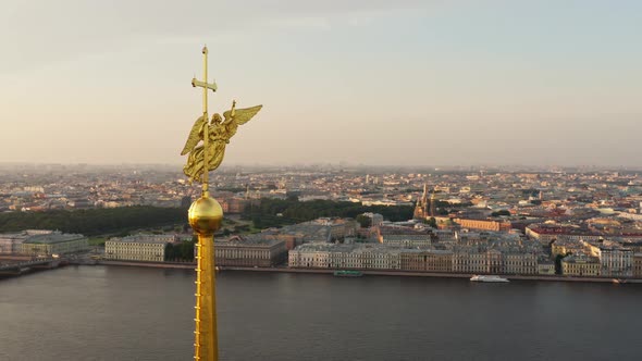 The Drone Flies Around the Golden Angel on the Cross of the Peter and Paul Fortress at Sunrise