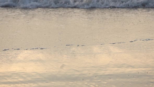 Slow motion of ocean waves coming in onto the beach.