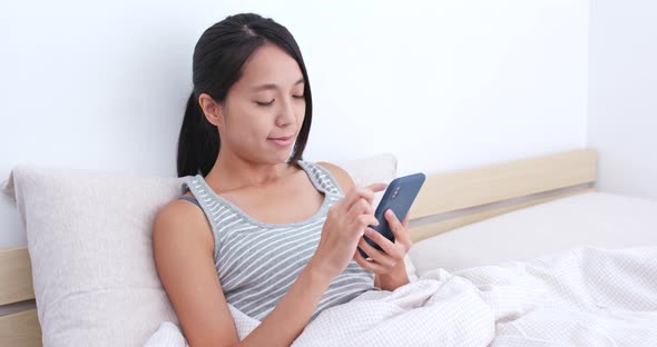 Woman use of mobile phone on bed