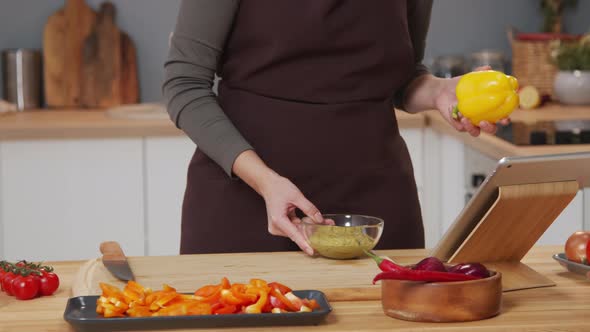 Woman Using Digital Tablet while Cooking Food