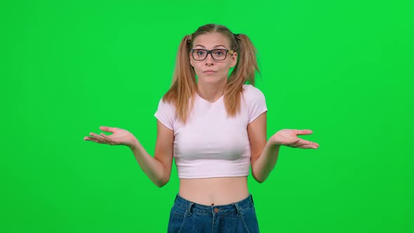 Female with Glasses Standing in Green Room and Looks at the Camera the Young Woman Expresses