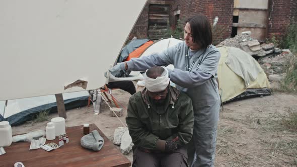 Medical Worker Giving First Aid to Refugee Man