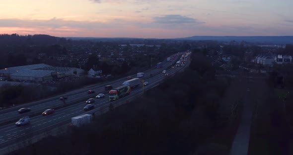 Wide aerial tracking shot of M20 motorway Aylesford, Kent, UK shot during rush hour at sunset.