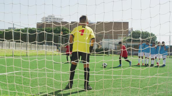 African American kid in red scoring in a sunny day