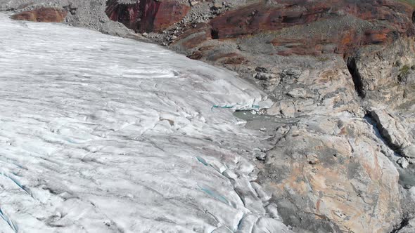Glacier ice sheet melting and fracturing in mountain valley, global warming