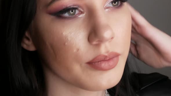 Young Woman with Beautiful Bright Evening Makeup Posing in Studio