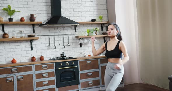 Asian Woman Doing Aerobic Fitness Jumping Exercises at Home