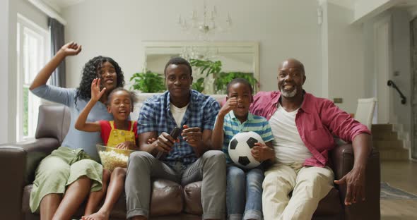 Happy african american family cheering while watching match in tv