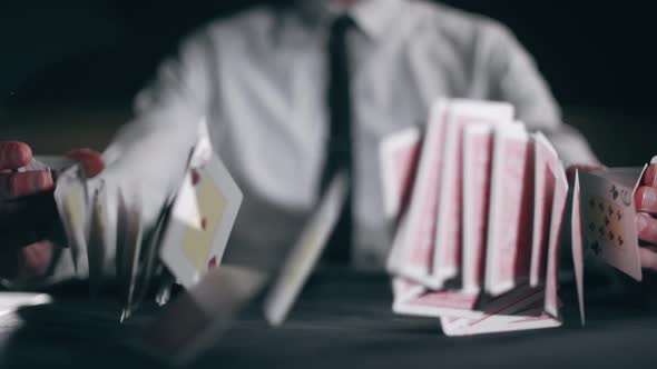 A Professional Croupier is Working and Shuffling with Cards