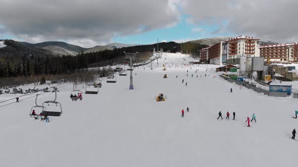 Aerial View on Lot of People Skiing on Ski Slopes Near Ski Lifts on Ski Resort
