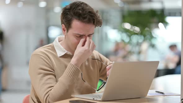 Man Having Headache While Working on Laptop