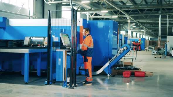 Factory Worker Operating a Modern Machine on a Refrigerator Assembly Line