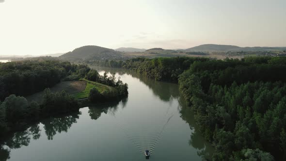 a small motorboat going slow on a small canal on the Danube