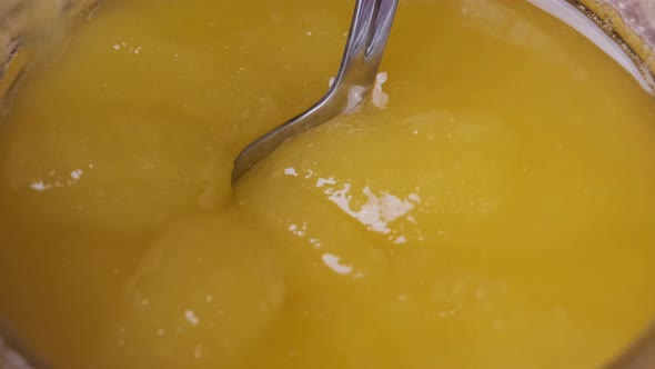 Crystalline Honey in a Jar, Macro, The Spoon is Dipped in thick Honey