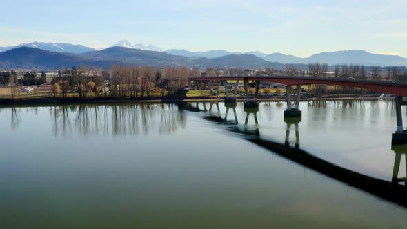 Crane Vessel Sailing At Fraser River Passing Under The Mission Bridge With Matsqui Prairie In BC, Ca