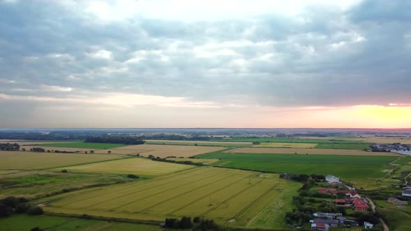 Aerial over British countryside landscape with farmland and fields at sunset