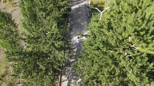 young man walking among the trees