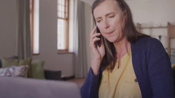 Woman talking on smartphone at home