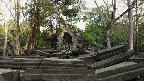 Man Steps Up Piledup Stone in Cambodia Ruins to Explore Surroundings