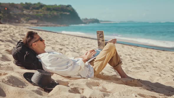 Young Millennial Remote Professional Works Away From the Office at the Beach