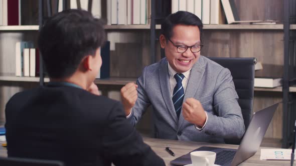 Two businessmen high fiving in celebrating victory successful stock deal.