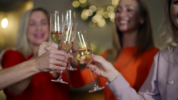 Clinking Glasses with Champagne in New Year Party Women are Celebrating and Drinking Alcohol