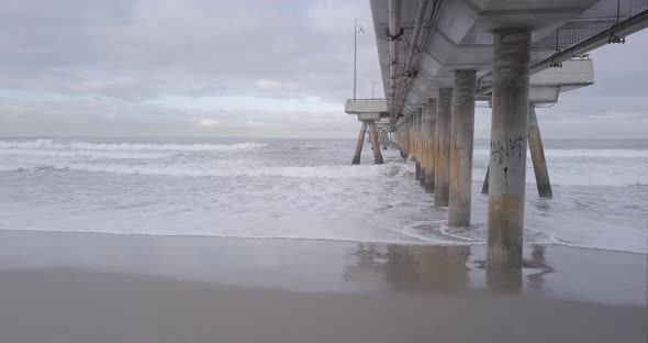 Flying under Venice Pier out to the side over the ocean to see surfers in the water