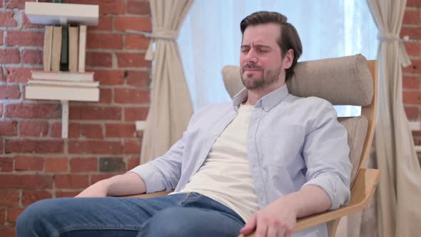Casual Young Man Worried While Sitting on Sofa