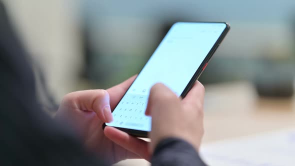 Rear View of Woman Text Messaging on Smartphone