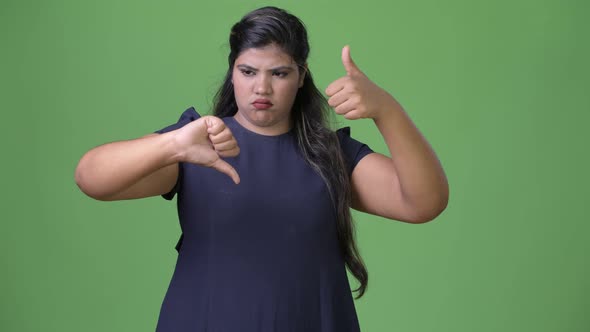 Young Overweight Beautiful Indian Businesswoman Against Green Background