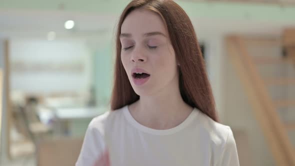 Portrait of Sleepy Redhead Young Woman Yawning