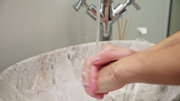 Woman Wash Her Hands with Soap in Bathroom