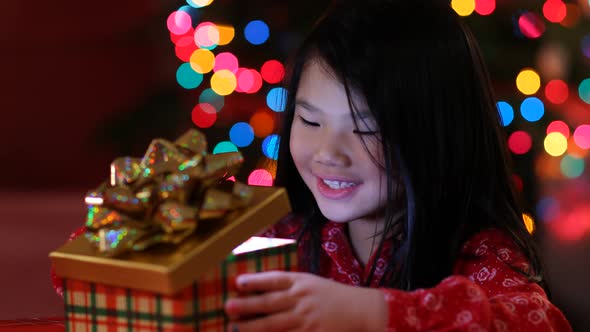 Young girl opens opens Christmas present