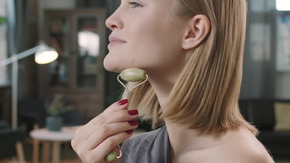 Woman Doing Facial Massage With Roller