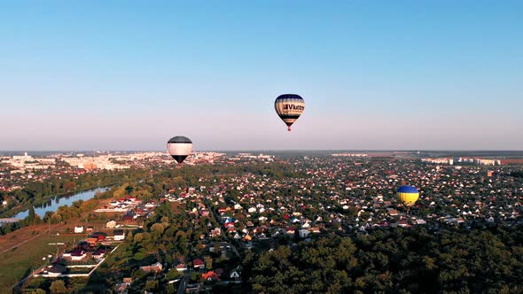 Beautiful balloons fly over the forest, park, city.