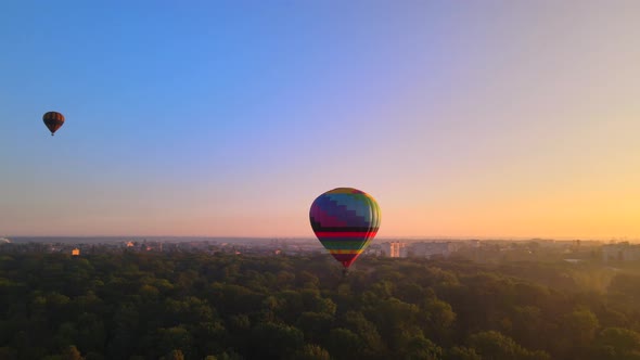 Aerial Drone View of Colorful Hot Air Balloon Flying Over Green Park and River in Small European