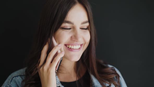 Portrait of Beautiful Brunette Speaking on the Phone and Laughing on Background