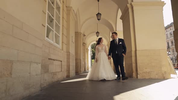Newlyweds Portrait Caucasian Groom Bride Walking Holding Hands on Lviv City Street Wedding Couple