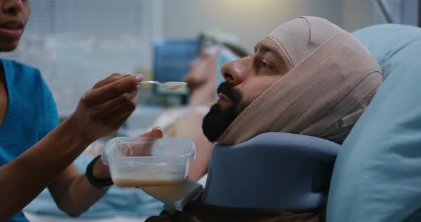 Nurse Feeding Injured Soldiers in Hospital Bed