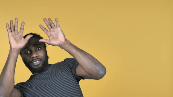 Casual African Man Confused and Scared of Problems Isolated on Yellow Background