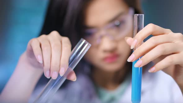 Asian Female Biologist Assistant Conducts Scientific Experiment Studying Chemical Reaction