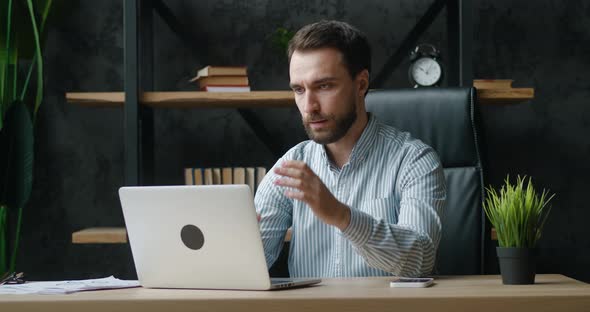 Unpleasantly Surprised and Shocked Businessman By the Bad News Seen on the Laptop Screen While