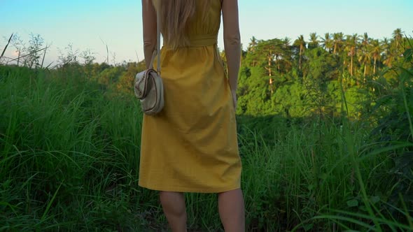 Super Slowmotion Shot of a Young Woman in a Yellow Dress Walking During Sunset at the Campuhan Ridge