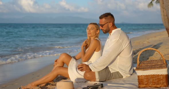 Lovely Two People Having Picnic on Evening Sandy Ocean Beach Enjoying Their Nice Conversation